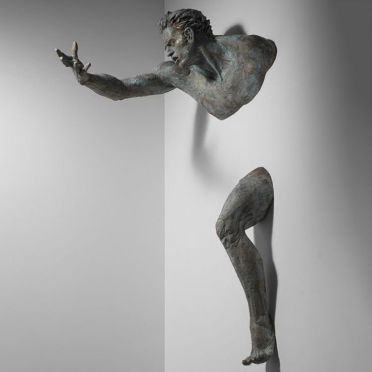 Famous cast bronze figure through wall sculpture