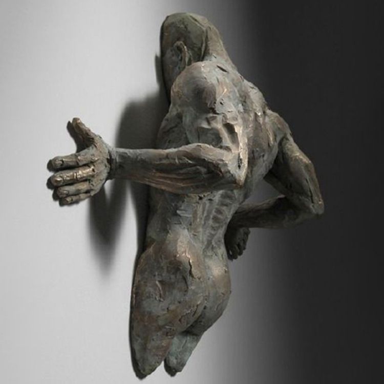 Famous cast bronze figure through wall sculpture