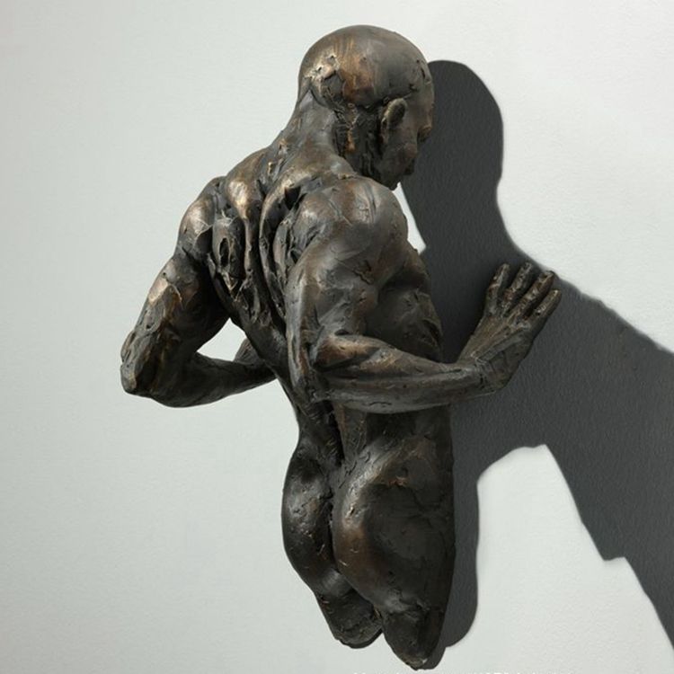 Famous cast bronze figure through wall sculpture