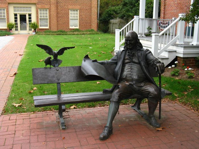 Life Size A sculpture of Benjamin Franklin sitting on the chair reading the Pennsylvania Gazette