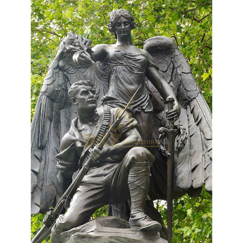 Bronze Depiction Of A Soldier Figure Who Is Protected By An Angel Statue