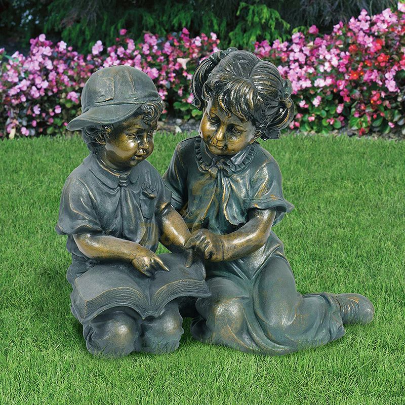 boy and girl reading book garden statue