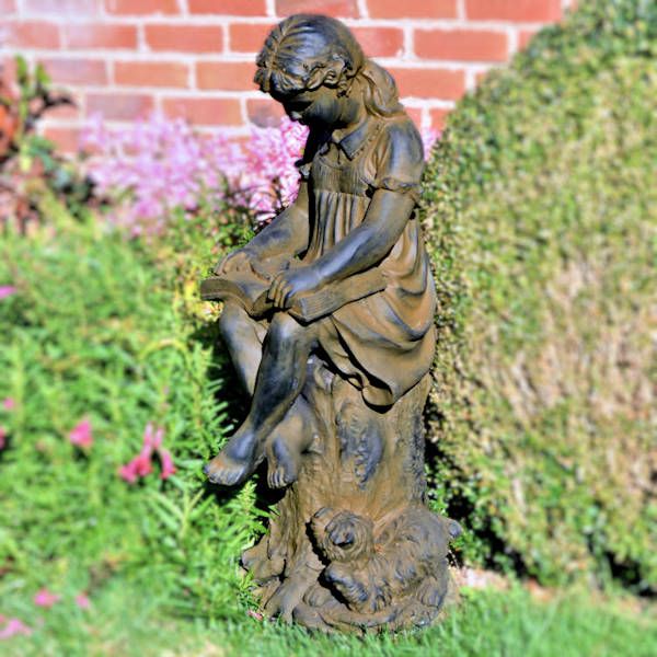 girl reading book garden statue