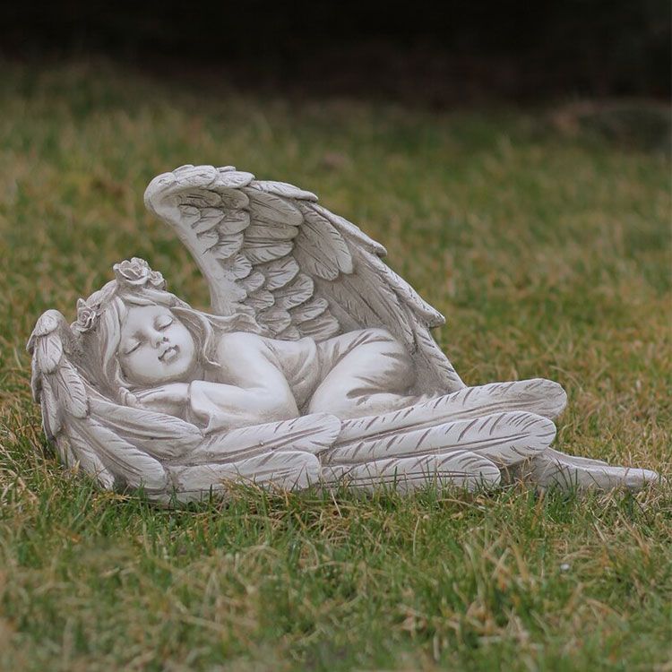 sleeping baby wrapped in angel wings statue