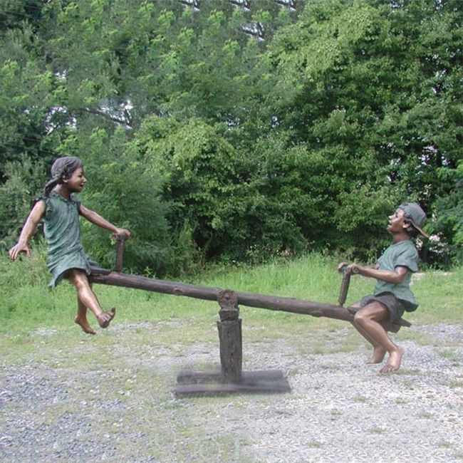 Boy and girl on seesaw garden statue