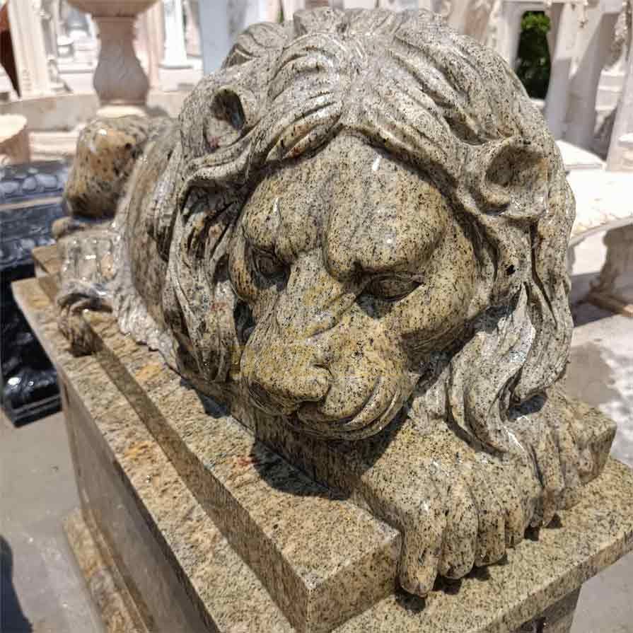 A male outdoor marble reclining lion statue