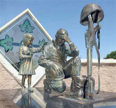 soldier kneeling at the cross