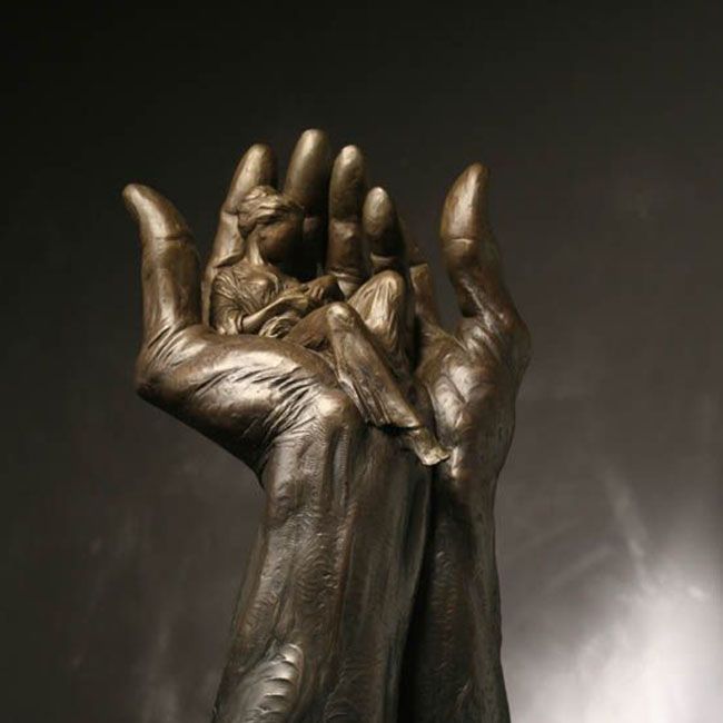 bronze hand holding mother and child sculpture