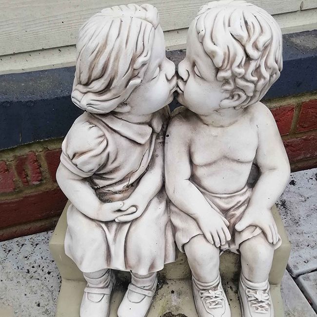 kissing boy and girl garden statue