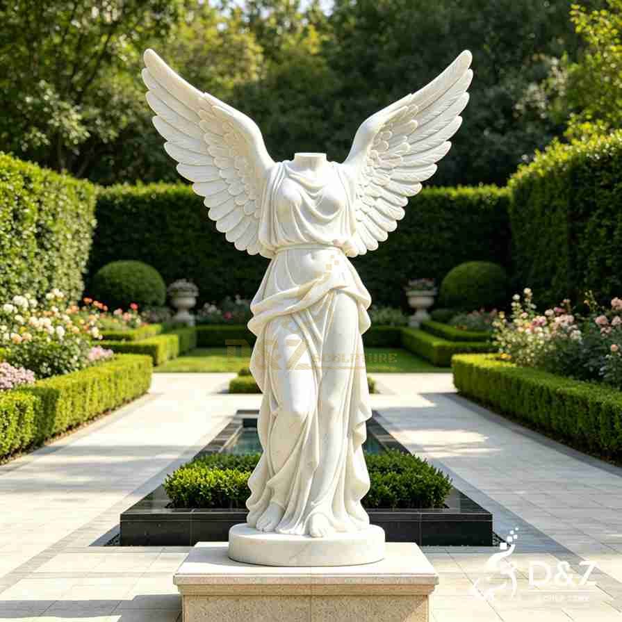 Large white marble headless angel statue with wide spread wings in formal garden Large white marble headless angel statue with wide spread wings in formal garden