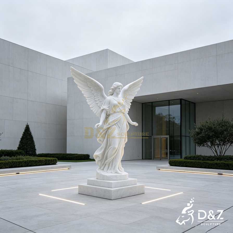Modern white marble angel statue with raised wings and open hands outside a contemporary cultural center