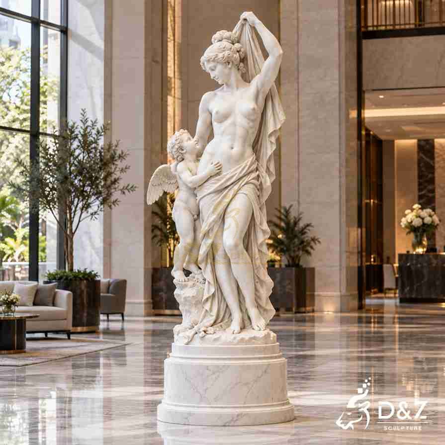 White marble Venus and Cupid statue with Venus lifting flowing drapery and Cupid looking upward beside her White marble Venus and Cupid statue with Venus lifting flowing drapery and Cupid looking upward beside her
