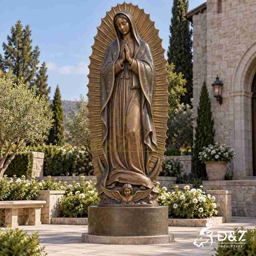 Bronze Guadalupe Virgin Mary statue with a star-patterned mantle, radiant rays, crescent moon, and angel below