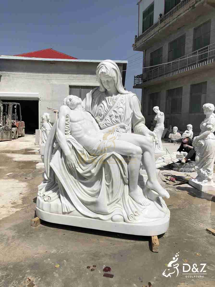Marble Pieta statue in a factory yard, showing Mary with one palm open and Jesus lying across her lap. Marble Pieta statue in a factory yard, showing Mary with one palm open and Jesus lying across her lap.